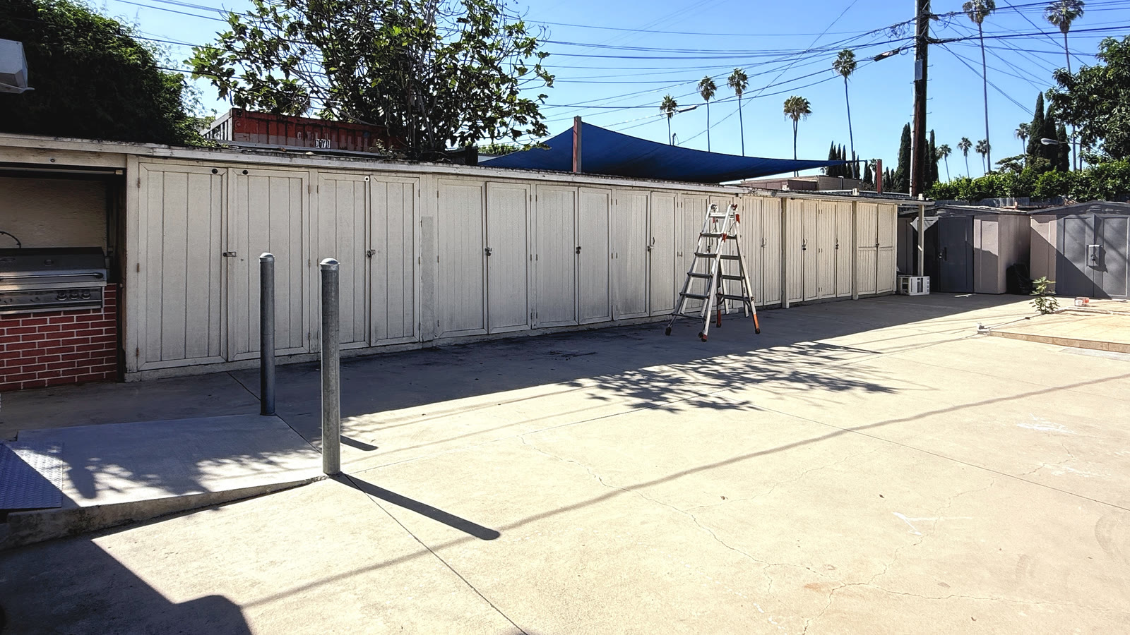 The long run of white storage cabinets on the rear wall, with the built-in grill in a recess at left.